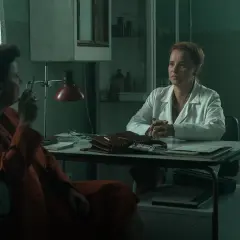 Dwie kobiety w gabinecie lekarskim. Jedna w białym kitlu, druga w pomarańczowym płaszczu, pali papierosa. Czy to scena z filmu "Ołowiane dzieci" czy na faktach?