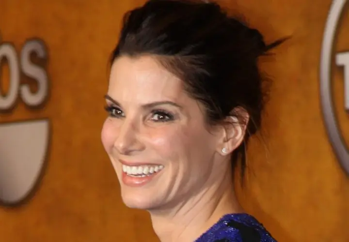Sandra Bullock 2024: Uśmiechnięta aktorka z błyszczącymi oczami i upiętymi włosami, na tle logotypów TBS i TNT.