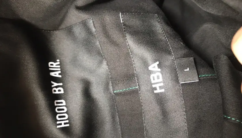 Metka z napisem HOOD BY AIR i HBA, rozmiar L, na czarnej podszewce.