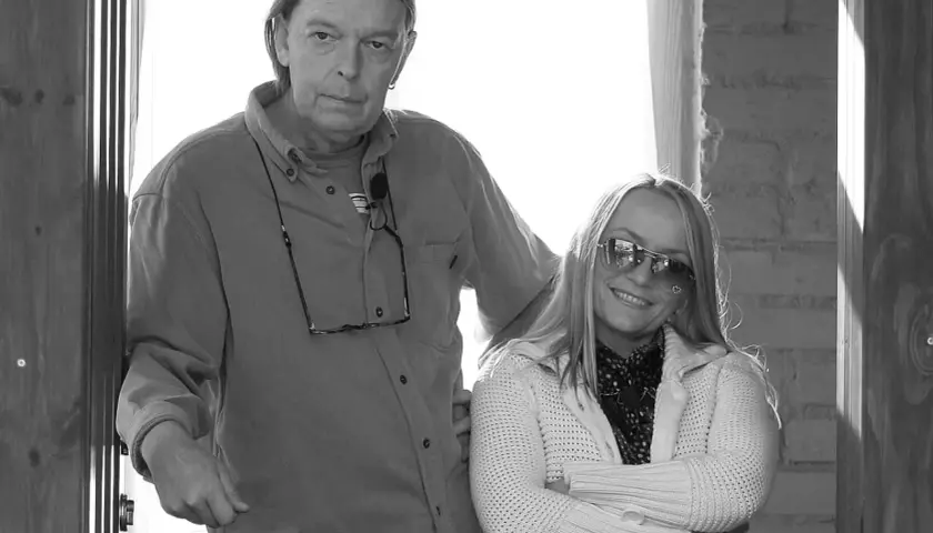 Małgorzata Ostrowska z mężem, uśmiechnięta kobieta w okularach przeciwsłonecznych i mężczyzna z długimi włosami.