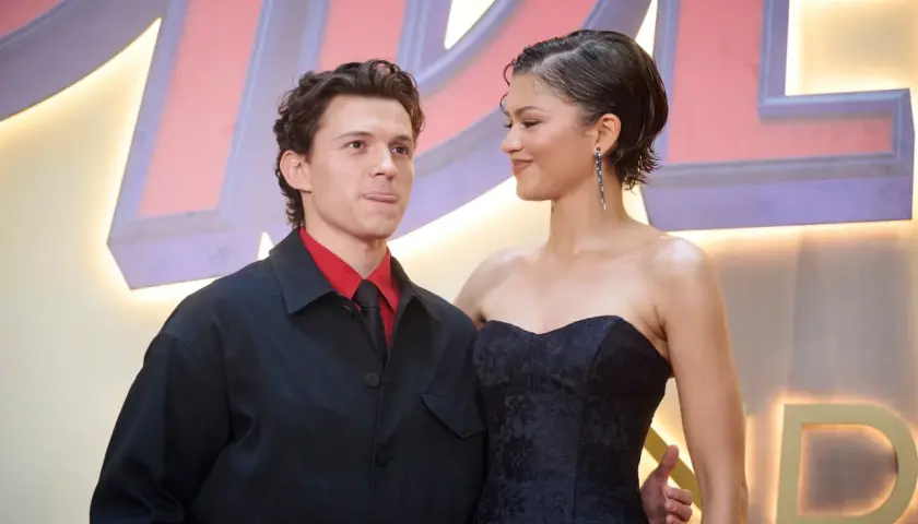 Zendaya i Tom Holland na premierze, ona w czarnej sukni, on w czerwonej koszuli i czarnej marynarce.