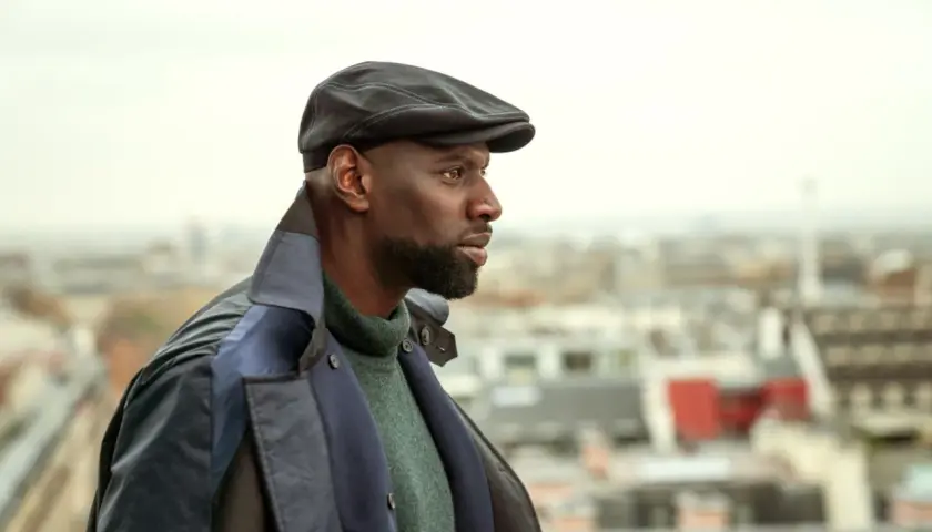 Omar Sy jako Assane Diop w czapce i płaszczu, spogląda w dal na tle Paryża. Czy to zapowiedź lupin sezon 4?
