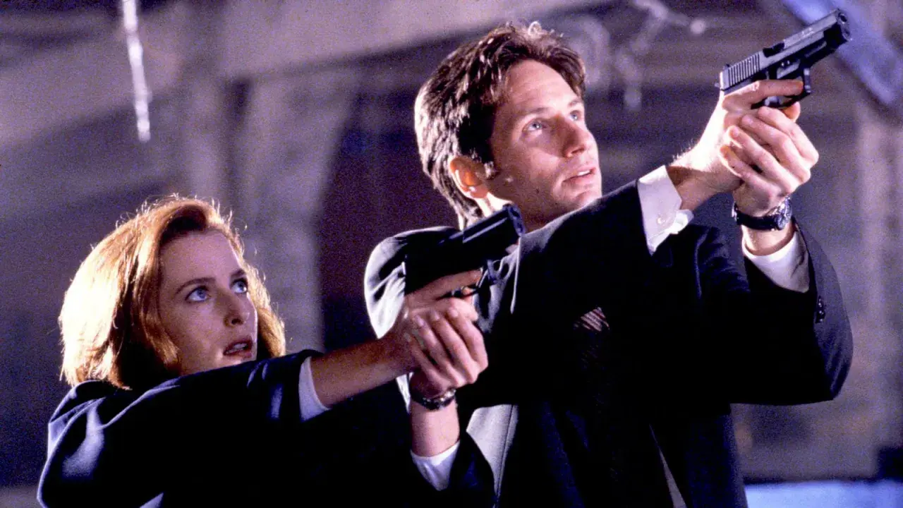 Z archiwum X: Scully i Mulder w akcji, celują z broni. Tajemnica czeka.