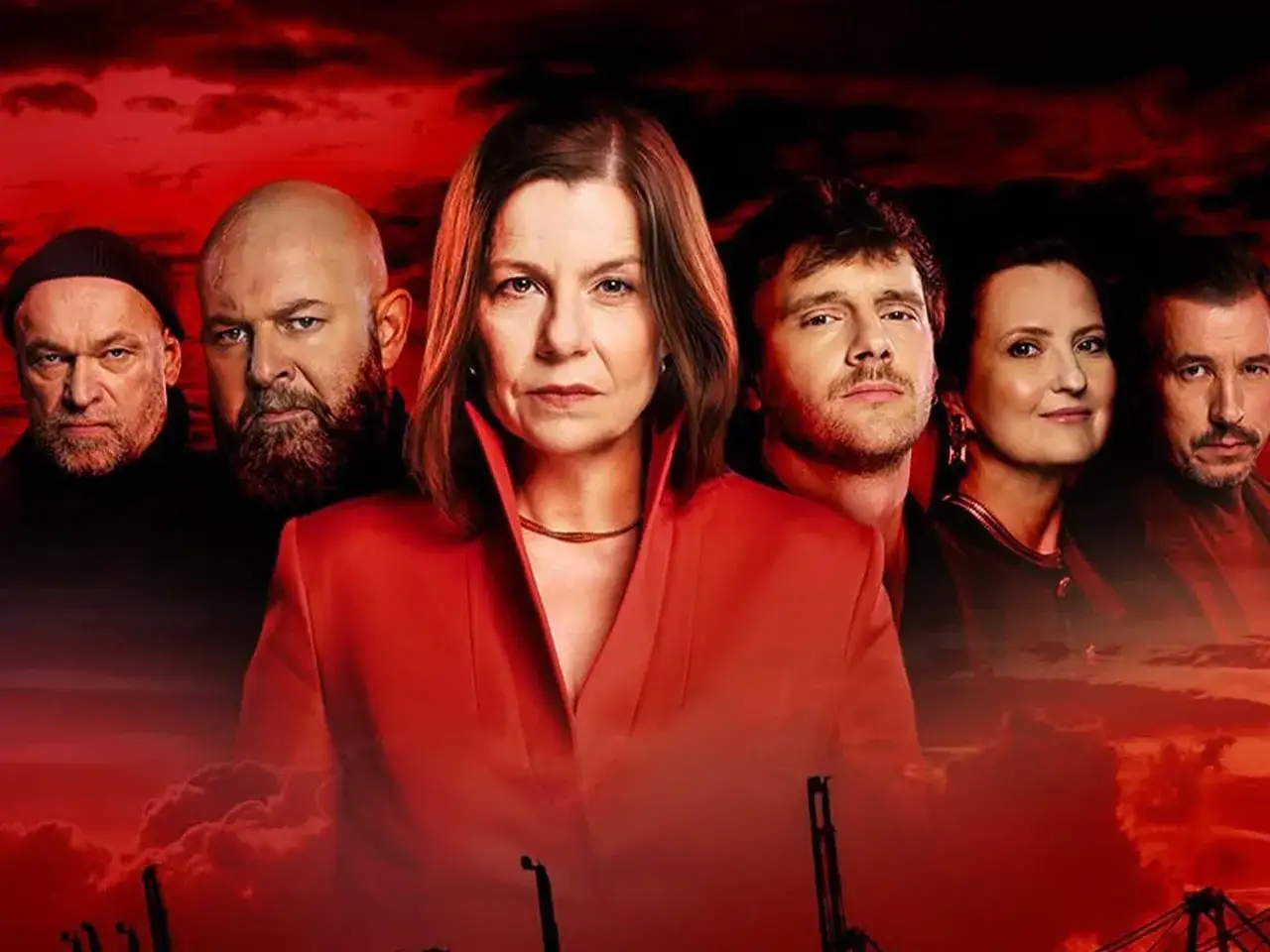 Grupa osób, w tym kobieta w czerwonej marynarce, na tle czerwonego, burzowego nieba. Wszyscy wyglądają poważnie, jakby byli ze sobą związani więzami krwi z krwi.